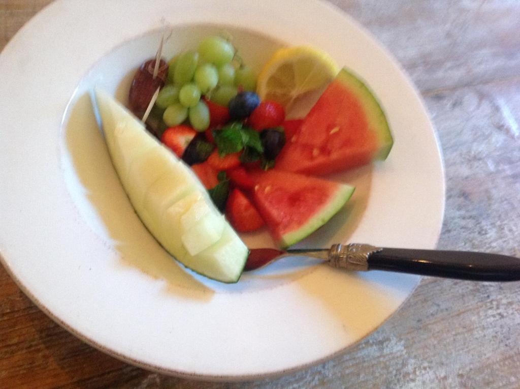 a white plate with a fruit salad on it at villaquinta in La Herradura