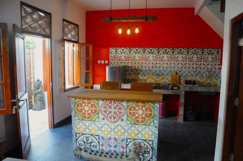 a kitchen with red walls and a colorful counter top at Villa Buddha Malioboro in Yogyakarta
