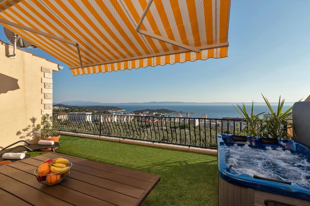 a deck with a table with a bowl of fruit on it at Apartment Gojak Mišo Alen in Makarska