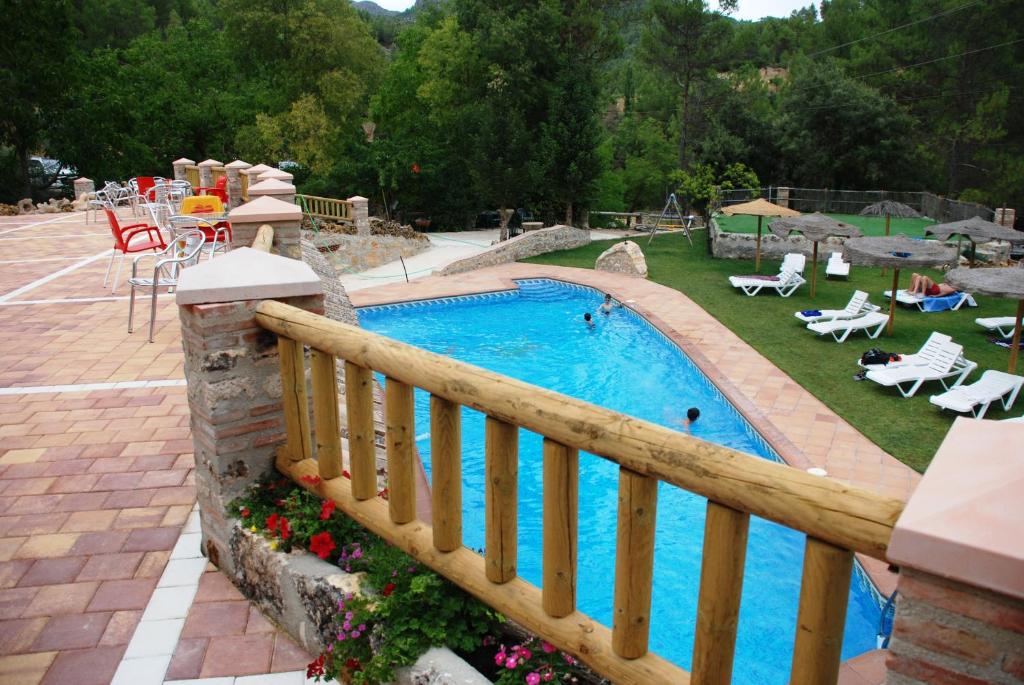 una piscina en un patio con una valla de madera en Hospedería Río Zumeta Spa en Santiago de la Espada