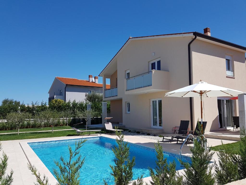 une villa avec une piscine et une maison dans l'établissement Villa Providenca Volme Hrvatska, à Banjole