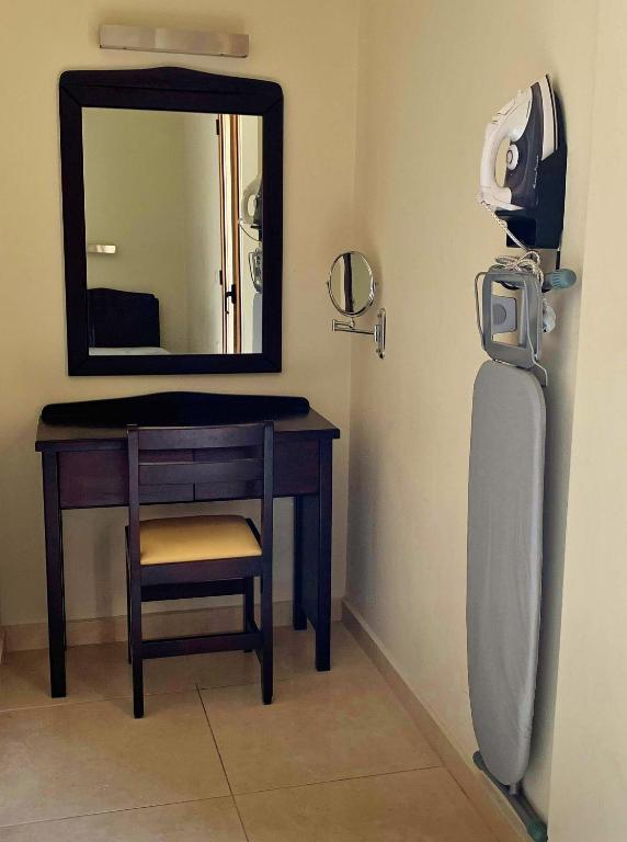 a room with a desk and a mirror and a phone at 24 Seven Boutique Hotel in Malia