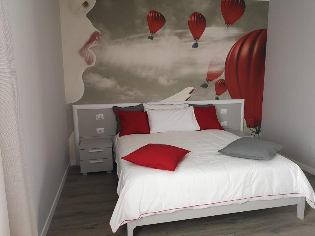 um quarto com uma cama branca com almofadas vermelhas e balões em Tra I Castelli em Filiano