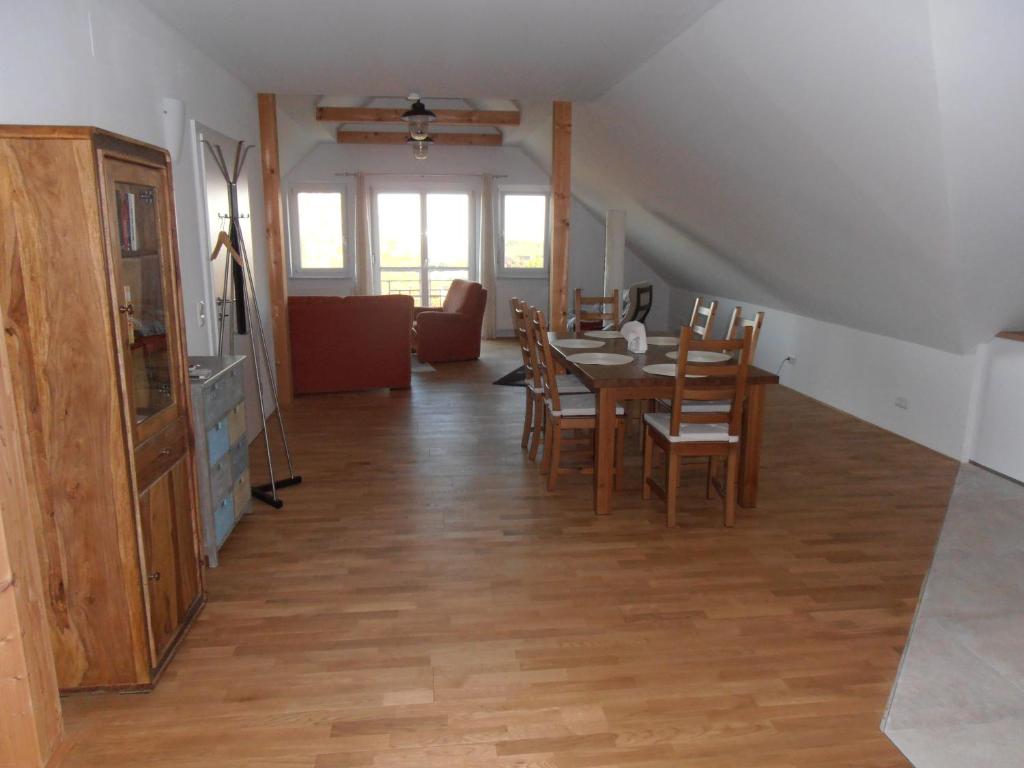 a dining room and living room with a table and chairs at Ferienwohnung am Kirchberg in Jois