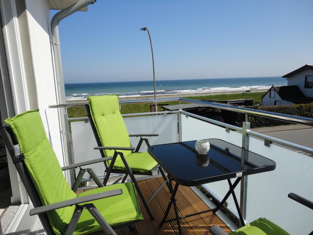 einen Balkon mit Stühlen, einem Tisch und Meerblick in der Unterkunft Ferienwohnung mit Meerblick in Dahme