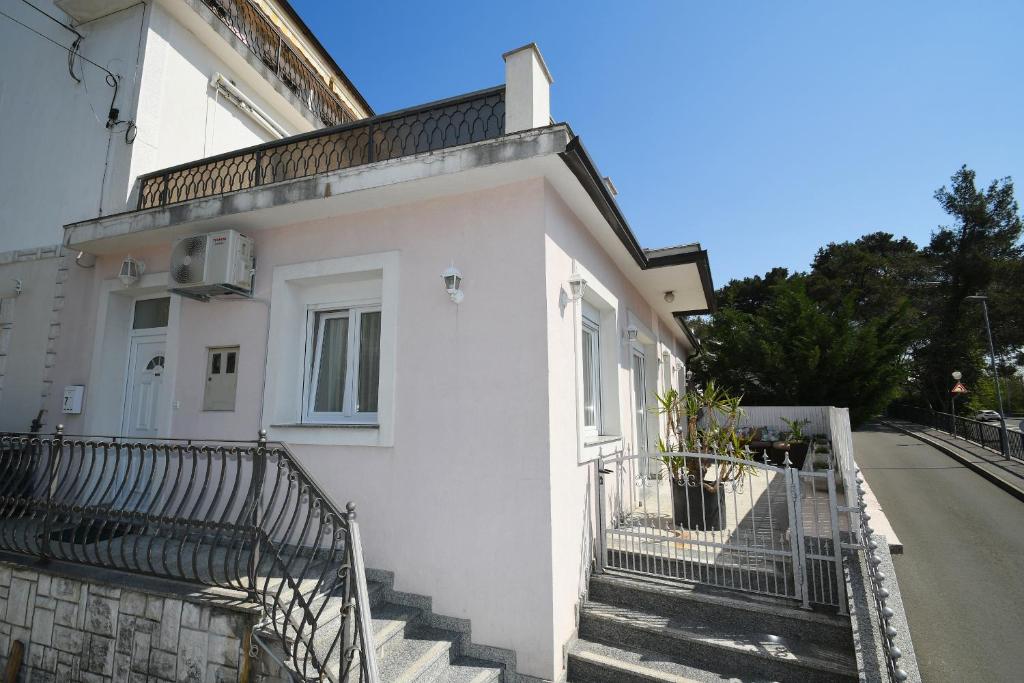 biały budynek ze schodami obok ulicy w obiekcie Apartment LIBRA with sea view w mieście Opatija