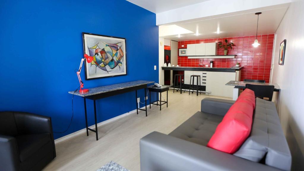 - un salon avec un canapé et un mur bleu dans l'établissement Bristol Metropolitan Curitiba Centro, à Curitiba