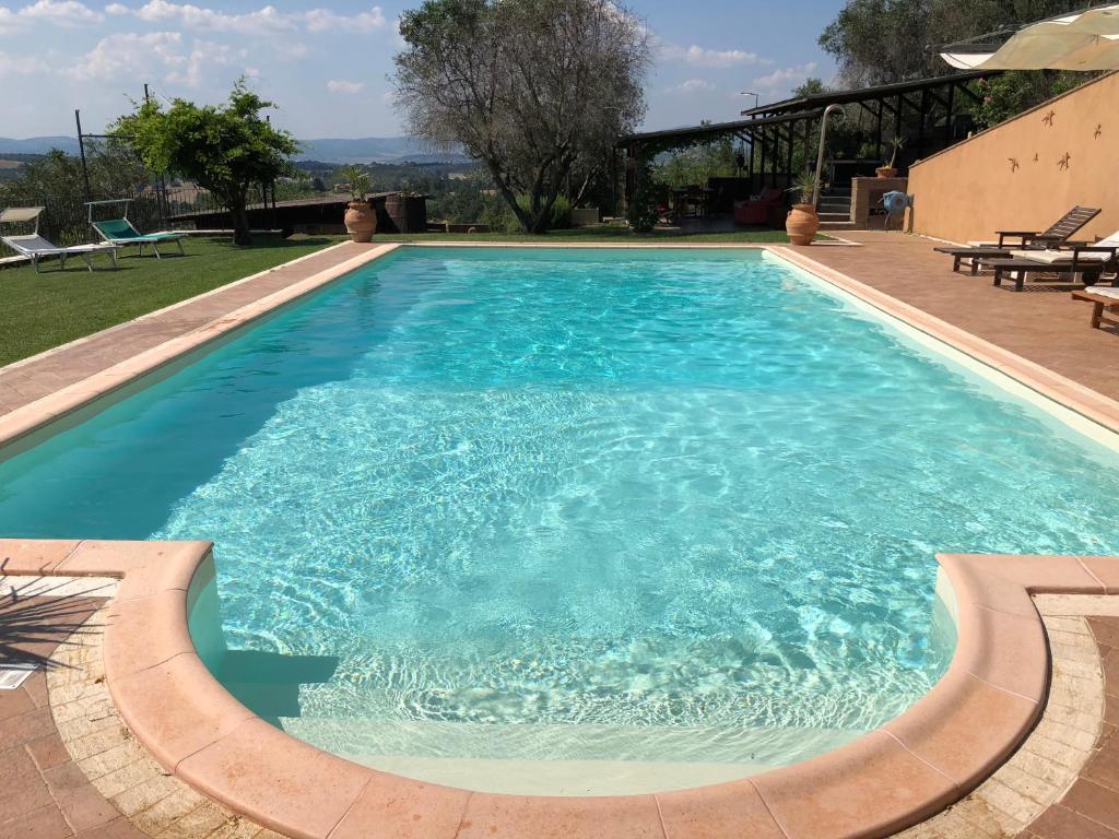 a large swimming pool with blue water at Il Pungitopo in Manciano