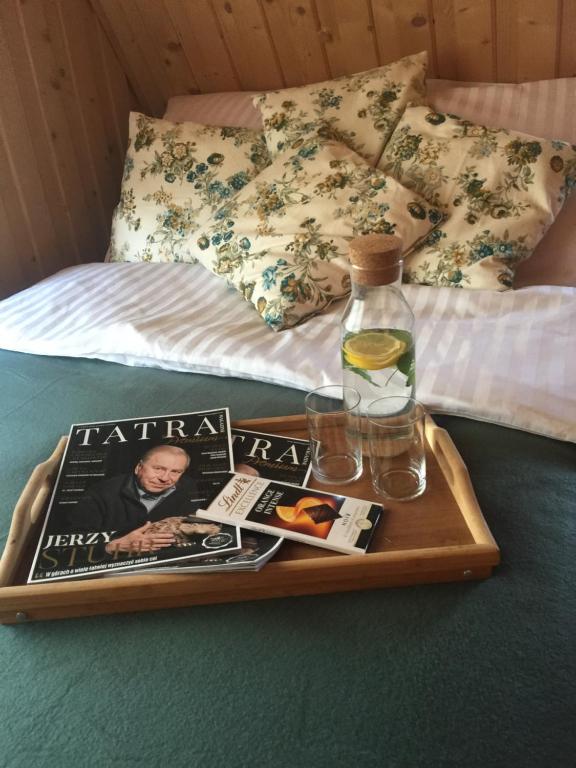 a tray with a magazine and a bottle on a bed at U Haliny - Blisko Term & Gorącego Potoku in Szaflary