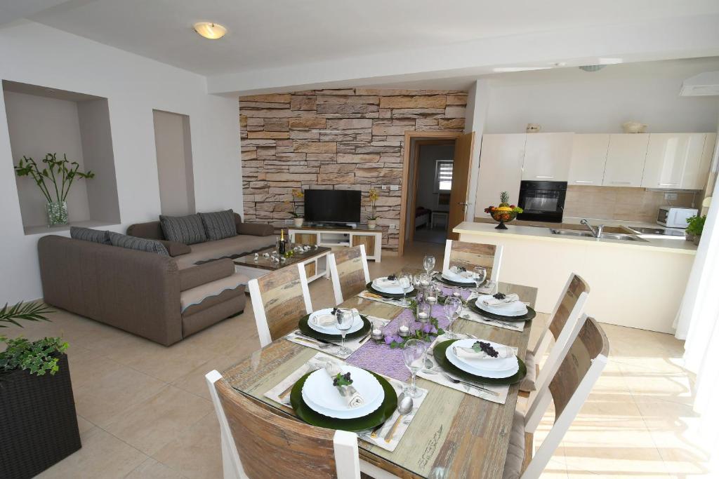 Apartment LIBRA with sea view في أوباتيا: طاولة طعام وكراسي في غرفة المعيشة