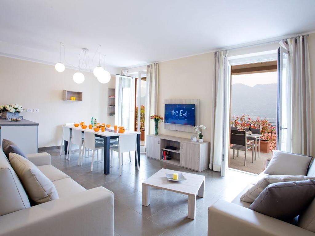 a white living room with a table and a dining room at SALA COMACINA RESIDENCE NO 4 in Sala Comacina