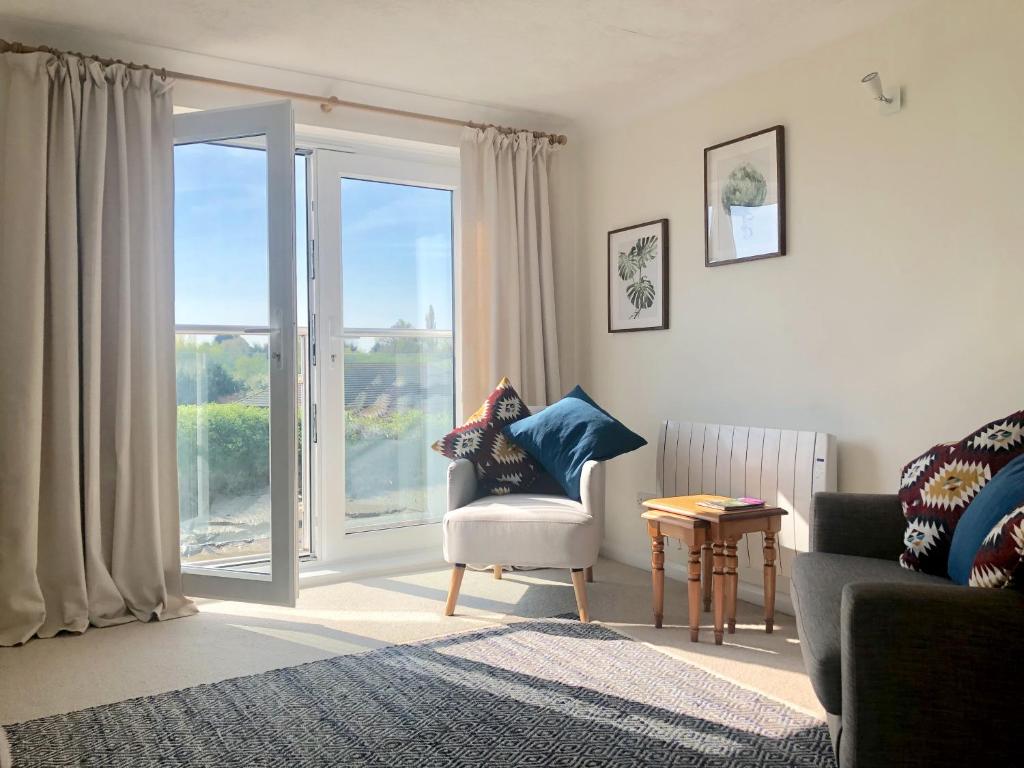 a living room with a chair and a large window at Waterside in Rye