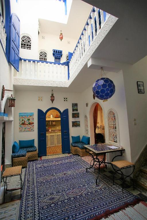 a living room with blue doors and a rug at Riad Terre d'Azur in Essaouira