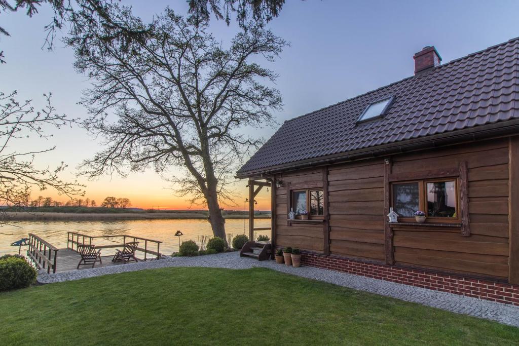 a log cabin with a view of the water at Domek nad Odrą in Gryfino