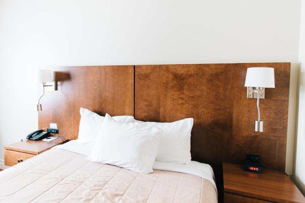 a bedroom with a large bed with a wooden headboard at Motel Mistral in Rouyn-Noranda