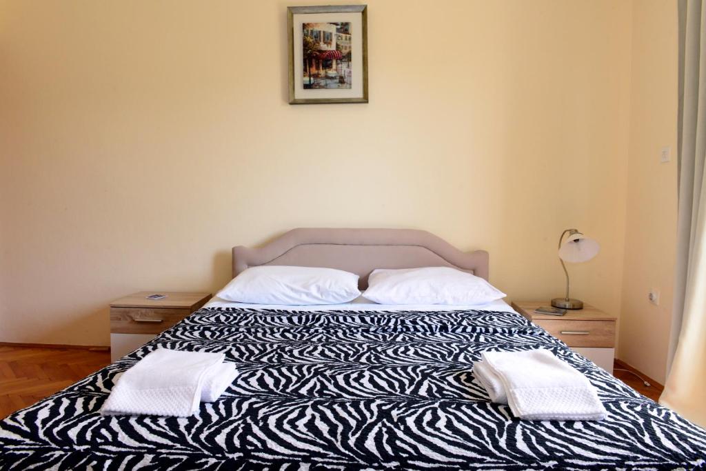 un letto con due cuscini sopra in una camera da letto di Sobe Tivat a Tivat