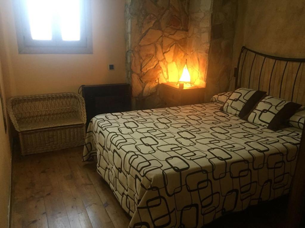 a bedroom with a bed and a lamp and a window at CAL PINTOR in Ibars de Noguera