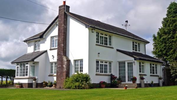 a white house with a brick chimney on a lawn at Chancery House in Highbray