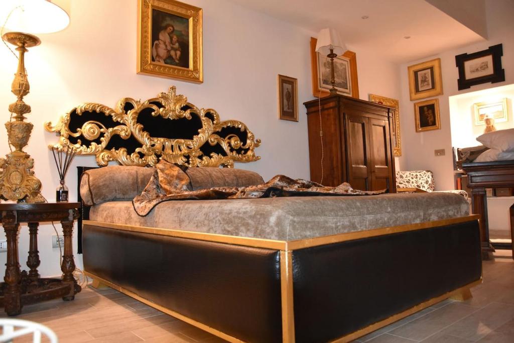 - une chambre avec un grand lit et une tête de lit en bois dans l'établissement ADRIANA, à Pisticci