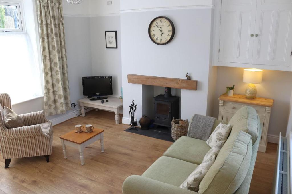 a living room with a couch and a fireplace at Pickles Cottage in Barnoldswick