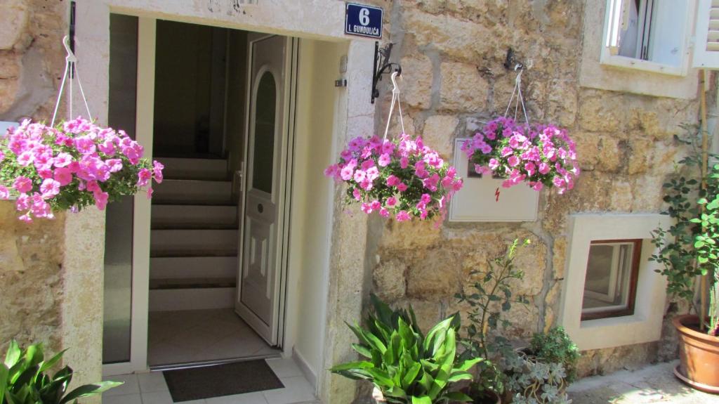 un edificio con dos cestas colgantes de flores rosas en Apartments Senko, en Trpanj