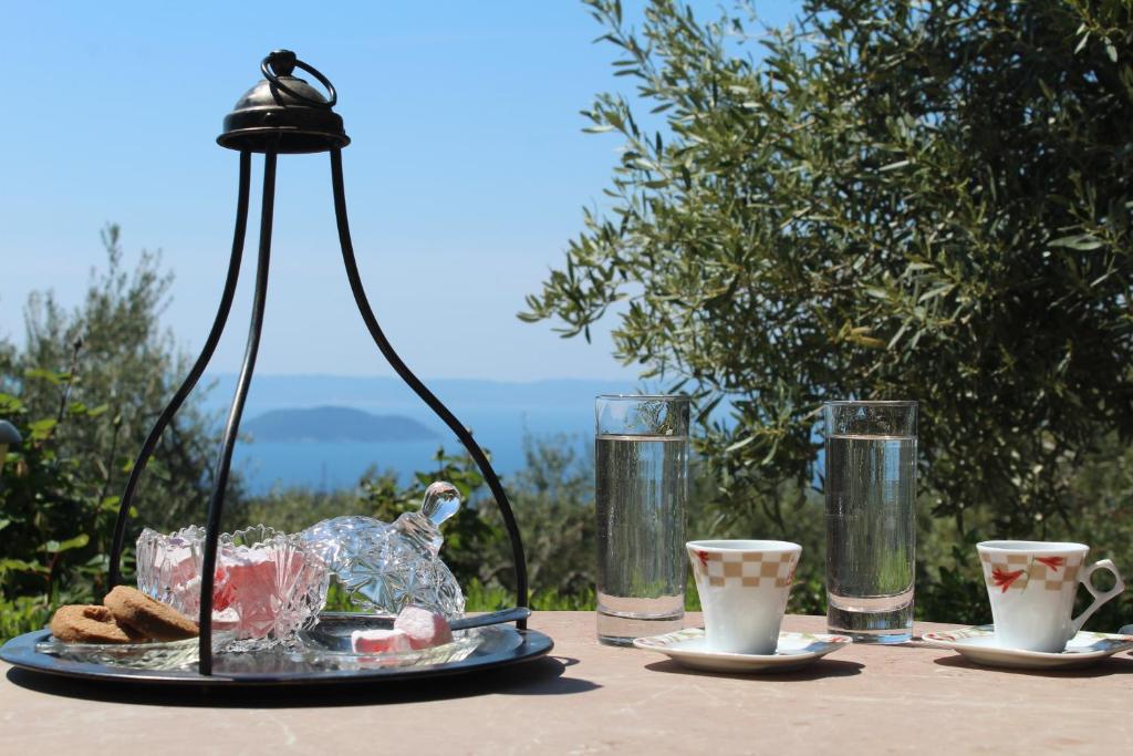 a table with a plate of food and two cups at Petrino Spiti in Parthenonas