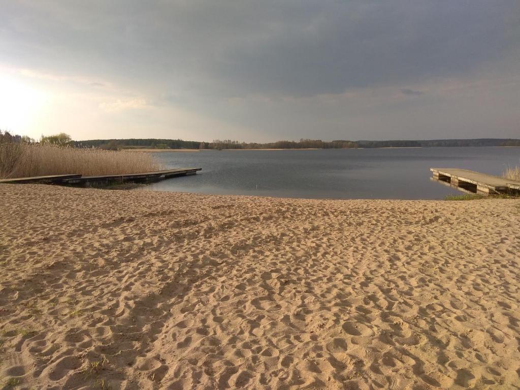 een strand met een pier en een waterlichaam bij Dom wakacyjny u Alicji in Pasym