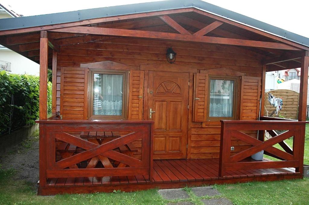 Cabaña de madera con puerta y 2 ventanas en Domek 100 m od morza, en Jastarnia