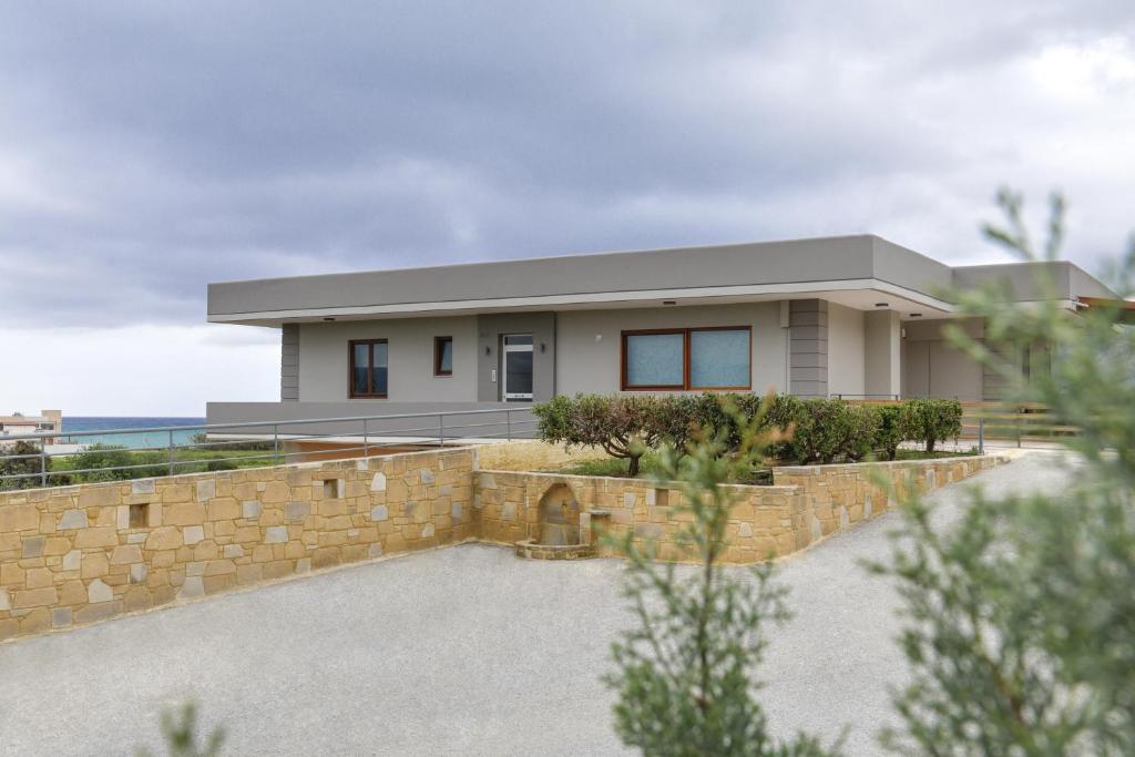 a house with a stone retaining wall at V & G Cozy Apartments in Kissamos