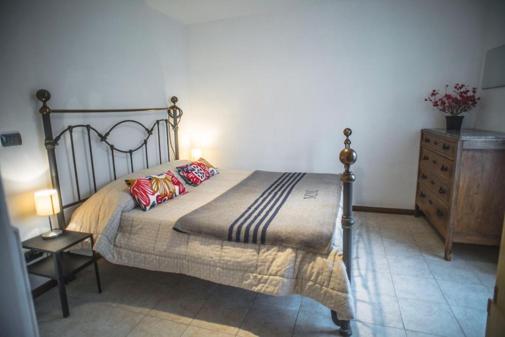 ein Schlafzimmer mit einem Bett und einer Kommode in einem Zimmer in der Unterkunft AUNTIE EVELYN'S HOME - Appartamento, Giardino&BBQ in Sestri Levante