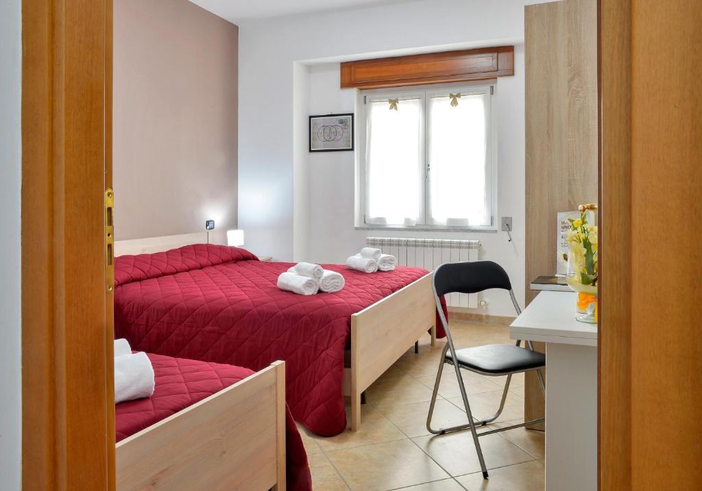 een slaapkamer met 2 bedden, een stoel en een raam bij Mastro Gio in San Giovanni in Fiore