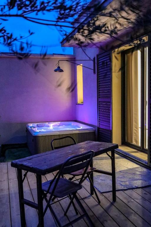 a bench sitting on a porch with a hot tub at Hôtel confidentiel Le Grecale in Pianottoli-Caldarello