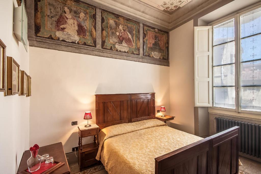 1 dormitorio con 1 cama y una pintura en la pared en Casa Rovai Guest House en Florencia