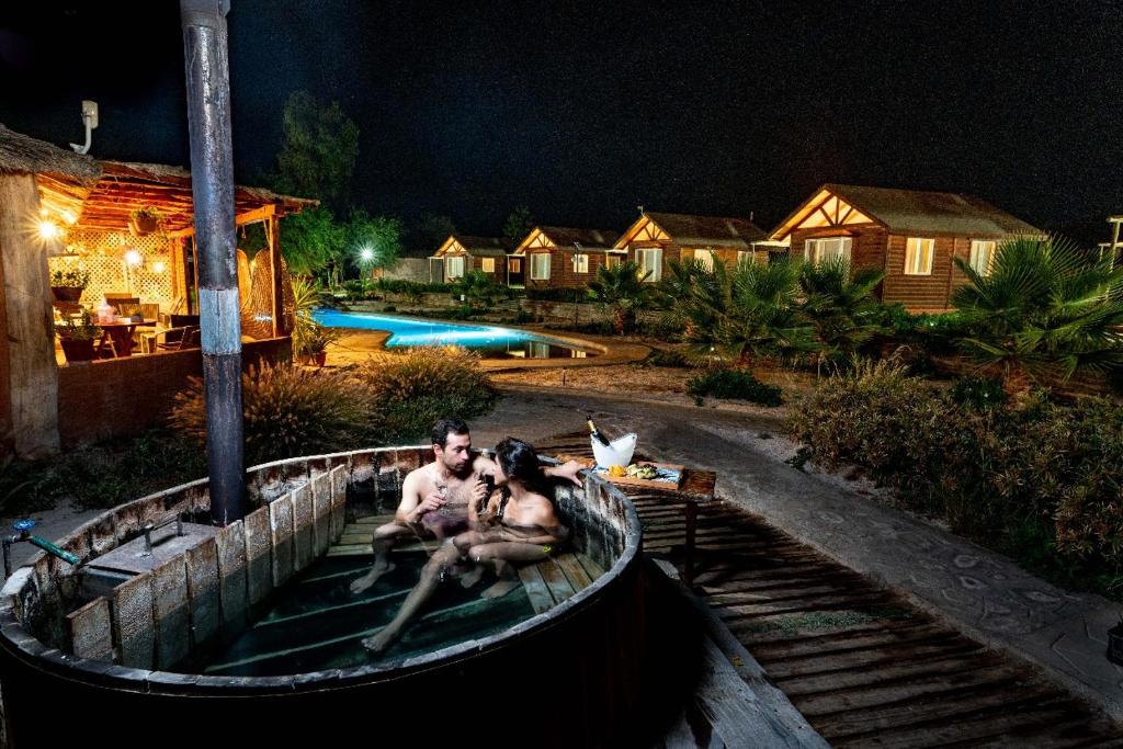 a man and a woman sitting in a boat in the water at Hotel El Bramador in Copiapó