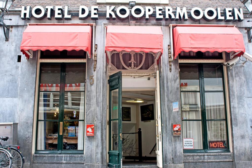 a hotel de kocioren with red awnings on a building at Koopermoolen in Amsterdam