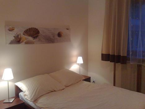 ヴロツワフにあるAparthouseのベッドルーム1室(ランプ2つ、絵画付)