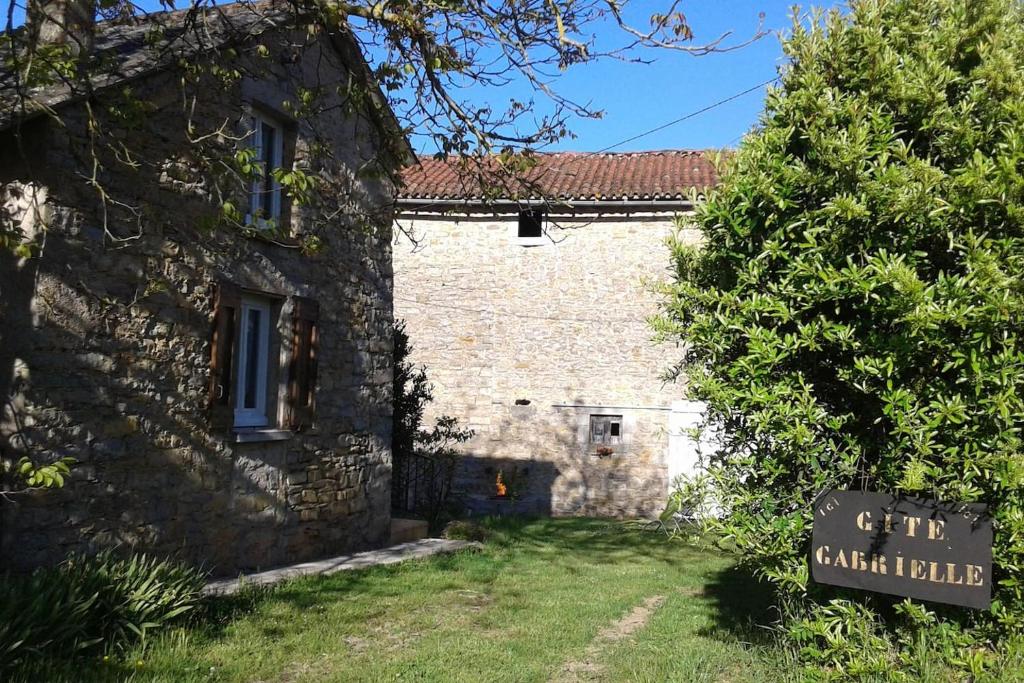 un vecchio edificio in pietra con un cartello di fronte di Gite Gabrielle a Saint-Jean-dʼAlcapiès