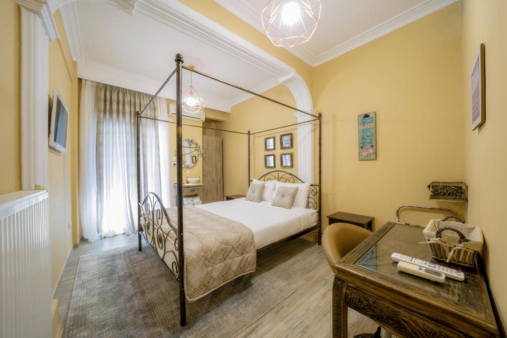 ein Schlafzimmer mit einem Himmelbett und einem Tisch in der Unterkunft Kentrikon deluxe Apt.(must) in Thessaloniki