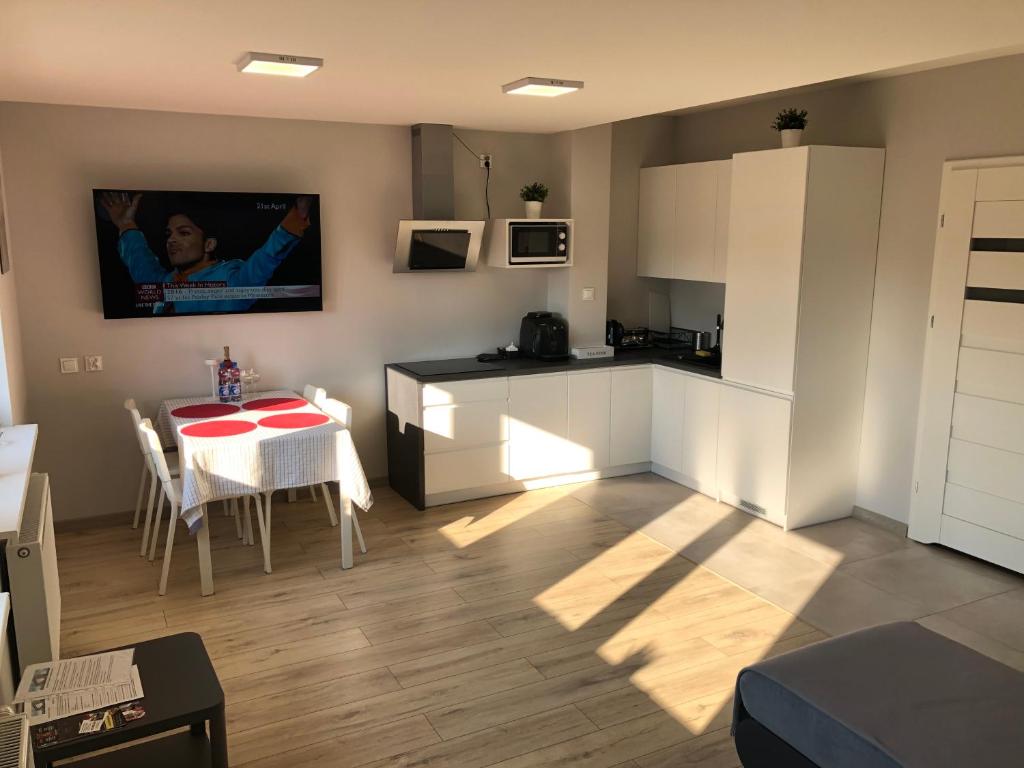 une cuisine avec une table et une petite cuisine avec une table et des chaises dans l'établissement Klimatyzowany Apartament Londyn, à Kielce