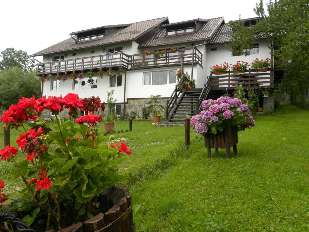 a house with flowers in front of it at Pensiunea Cerbul Carpatin in Bran