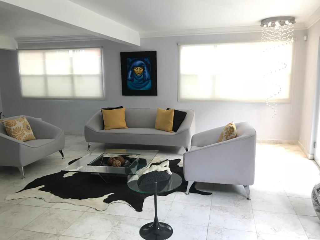 Sala de estar con 2 sofás y mesa en Casa Sofia en Guaynabo