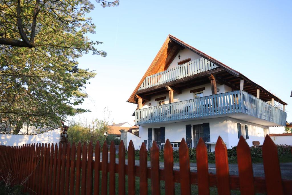 ein weißes Haus mit Balkon auf einem Zaun in der Unterkunft Gästehaus Roensch in Frensdorf