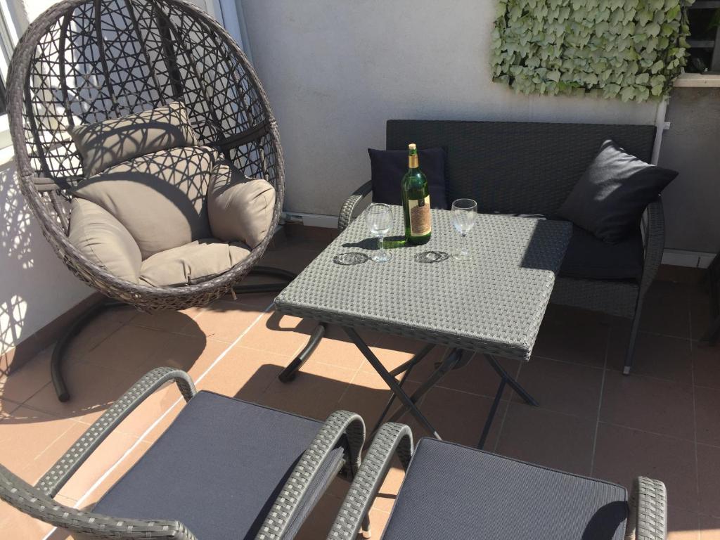 einen Tisch und Stühle auf einem Balkon mit einer Flasche Wein in der Unterkunft Apartment Poetry in Split