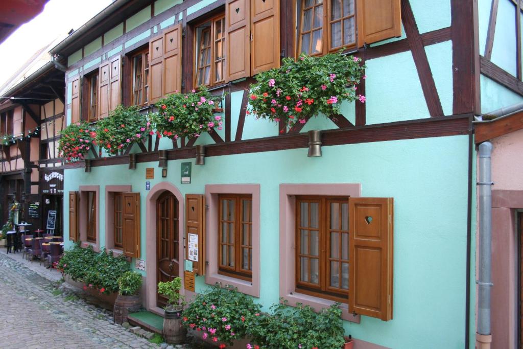 un edificio con muchas ventanas y flores en él en Résidence Vénus, en Eguisheim