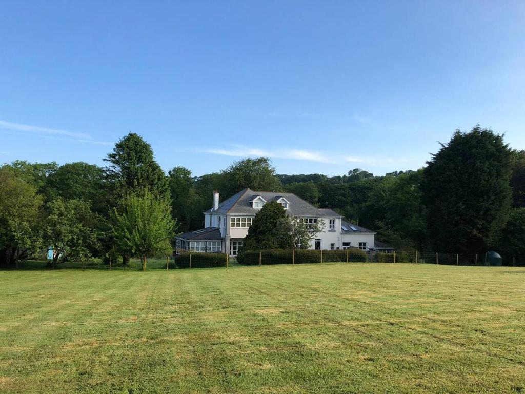 un gran campo frente a una casa blanca en The Annexe, Tregoose House, en Newquay