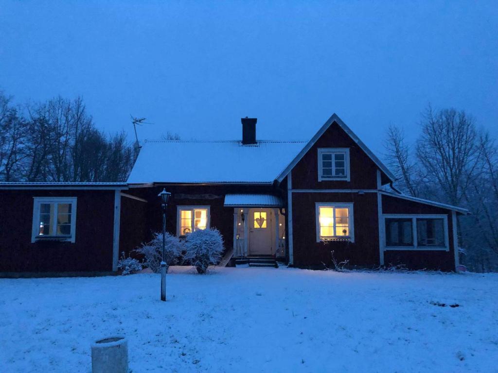 una casa con sus luces encendidas en la nieve en Nordhagen Gate en Hjo