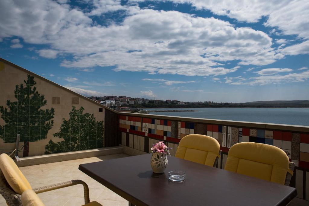 a table and chairs on a balcony with a view of the water at Apartments Svijet Mora 2 in Povljana