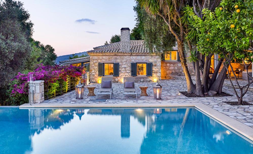 una casa con piscina di fronte a una casa di Villa Ioli- Beachfront Luxury Residence a Igoumenítsa