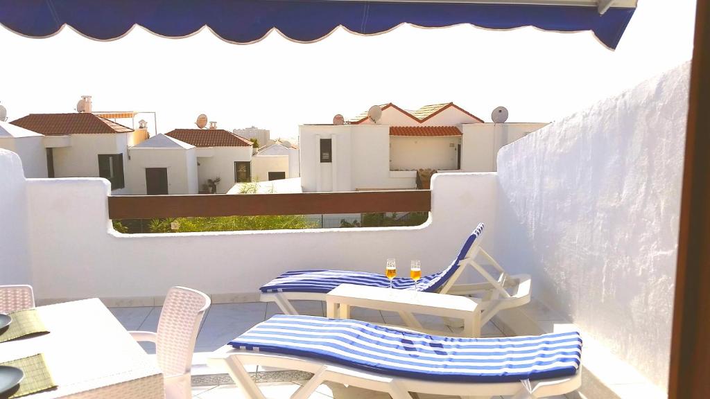 a patio with two chairs and a table on a balcony at Charming studio Los Cristianos Hill heated pool in Los Cristianos