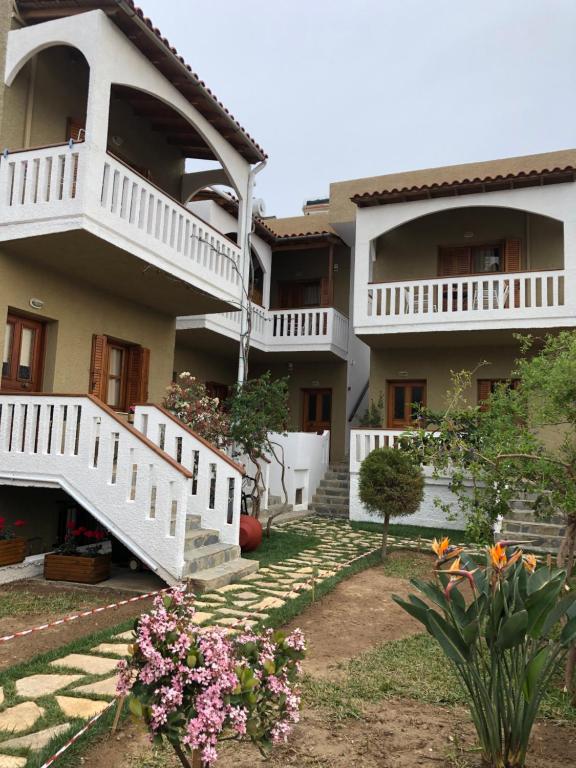 a house with white stairs and flowers in the yard at Nicolas Beach in Palaiochora